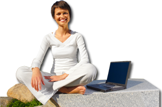 Uśmiechnięta kobieta siedzi po turecku na kamiennej ławce, a obok niej leży otwarty laptop.